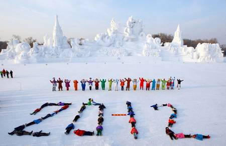 Các em nhỏ tại Cáp Nhĩ Tân, tỉnh Hắc Long Giang, đông bắc Trung Quốc nằm trên tuyết để xếp thành hình con số 2012.