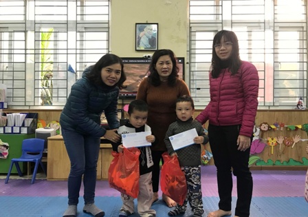 Cô giáo Ngô Kim Liên cùng Ban phụ huynh lớp trao quà cho gia đình  trẻ