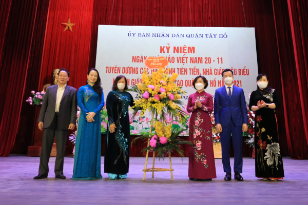 Bà Lê Thị Thu Hằng TUV, Bí thư Quận ủy, Chủ tịch HĐND quận ( đứng bên phải lẵng hoa) cùng lãnh đạo quận Tây Hồ tặng hoa chúc mừng ngành GD&ĐT quận.