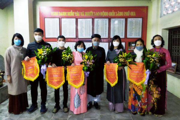 Đồng chí Phạm Thị Thùy Linh (Phó chủ tịch UBND phường) và Ban Tổ chức lễ hội đình Phú Gia trao cờ vinh danh hiền tài tại nhà Văn chỉ ngày 9-2-2022