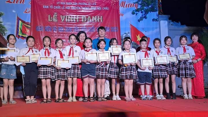 Bà Phan Thị Huyền - Chủ tịch Hội khuyến học phường Tứ Liên trao thưởng cho các em học sinh